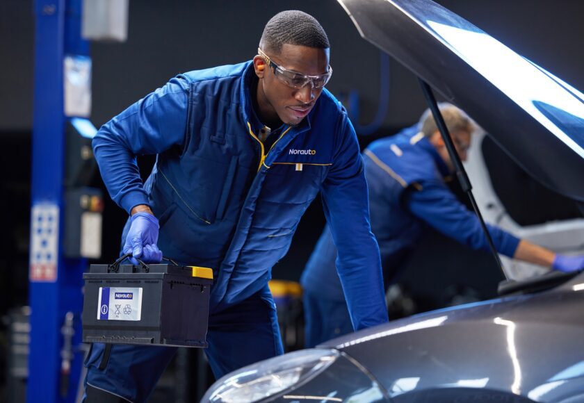 Homme en atelier Norauto remplaçant une batterie de voiture